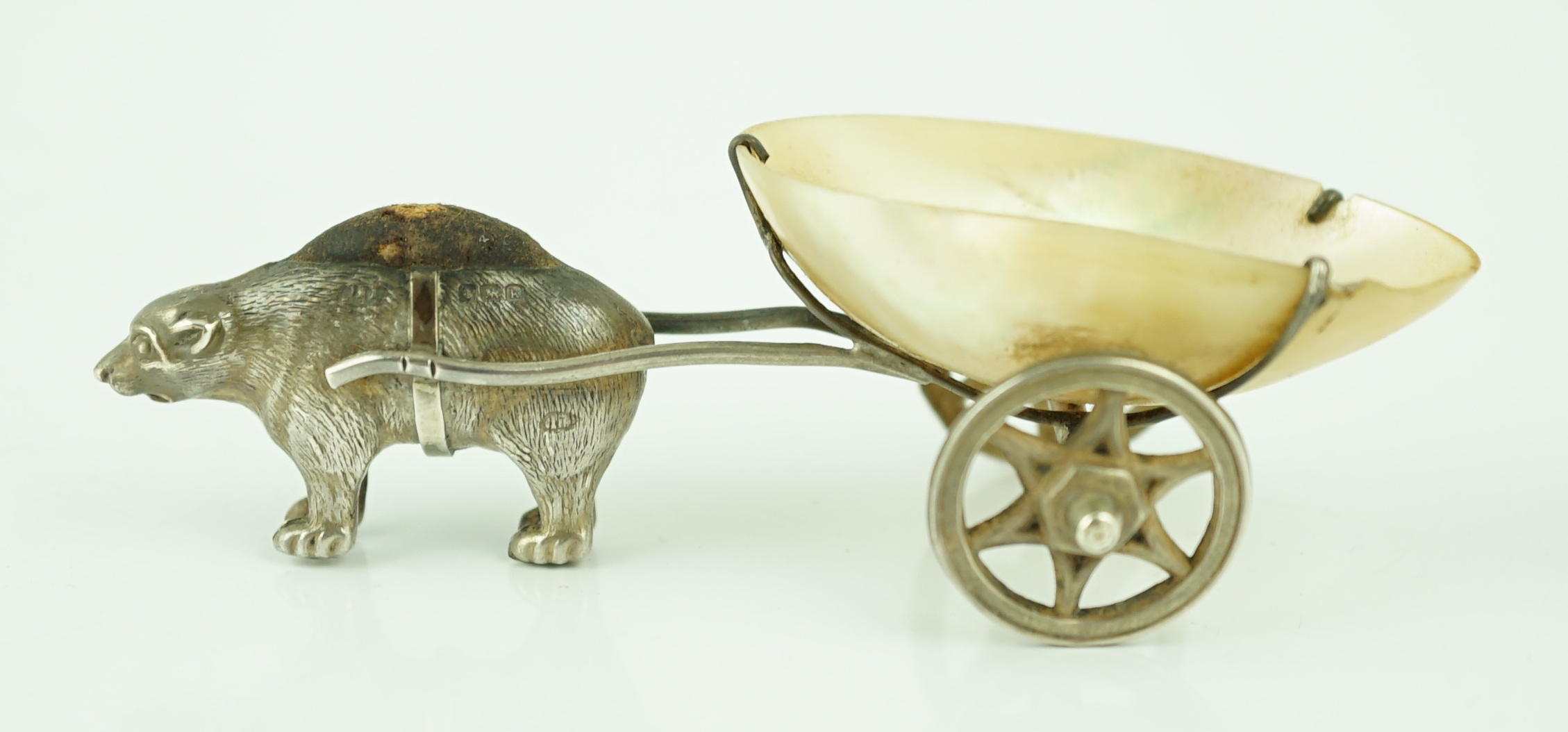 An Edwardian novelty silver and mother of pearl pin cushion, modelled as a bear pulling a cart, Adie & Lovekin Ltd